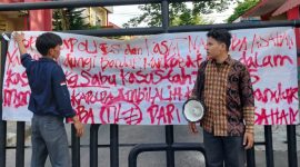 Nampak aktivis GMPSU membentangkan kain putih pada gerbang pintu Polres Asahan bertuliskan desakan untuk pengusutan kasus jaringan Narkotika di Sumatera Utara. ©setara.info/M. Idris Sarumpaet