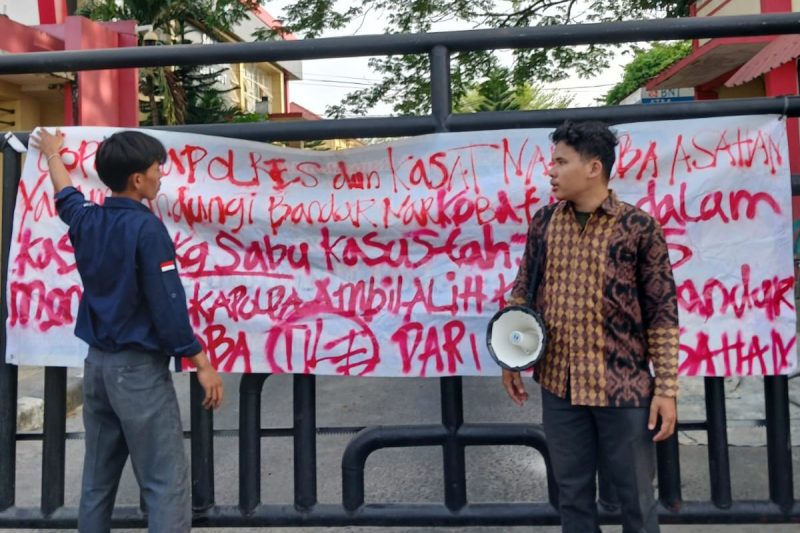 Nampak aktivis GMPSU membentangkan kain putih pada gerbang pintu Polres Asahan bertuliskan desakan untuk pengusutan kasus jaringan Narkotika di Sumatera Utara. ©setara.info/M. Idris Sarumpaet