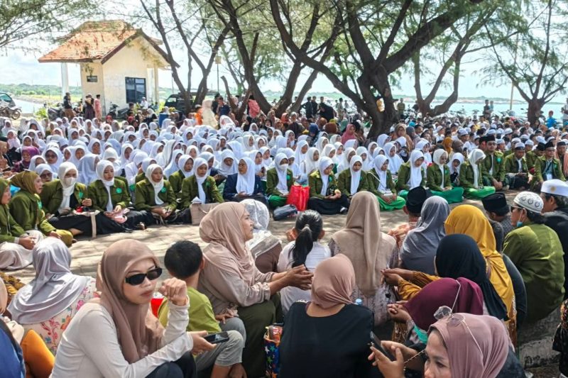 Para santri dan santriwati Sukorejo yang hendak balik ke pesantren melantunkan sholawat dan burdah sebelum keberangkatan di Pelabuhan Ferry Raas. ©setara.info/istimewa