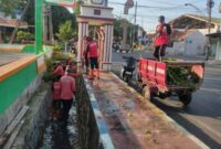 Satgas Pasukan Merah saat melaksanakan Bersih bersih Saluran di Jalan HOS Cokroaminoto.