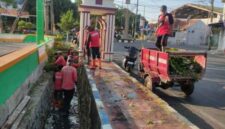 Satgas Pasukan Merah saat melaksanakan Bersih bersih Saluran di Jalan HOS Cokroaminoto.