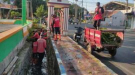 Satgas Pasukan Merah saat melaksanakan Bersih bersih Saluran di Jalan HOS Cokroaminoto.