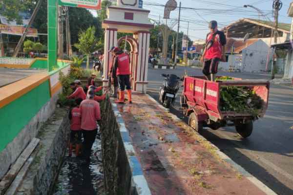 Satgas Pasukan Merah saat melaksanakan Bersih bersih Saluran di Jalan HOS Cokroaminoto.